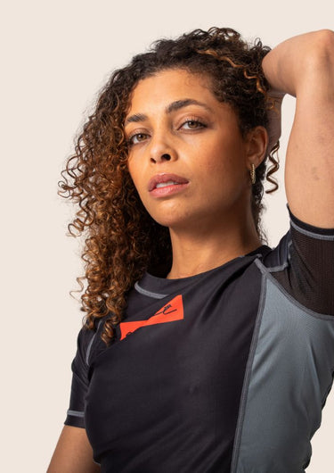 Women’s technical BJJ rashguard in black and red, featuring four‑way stretch and mesh ventilation.
