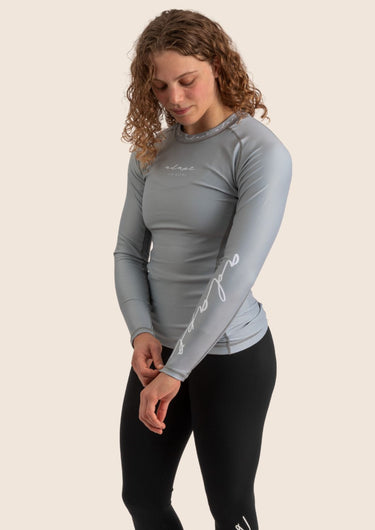Women’s long‑sleeved technical BJJ rashguard in Silver, featuring four‑way stretch and mesh ventilation. Unique womens fit.