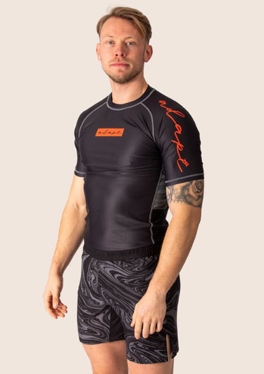 Men’s technical BJJ rashguard in black and red, featuring four‑way stretch and mesh ventilation.