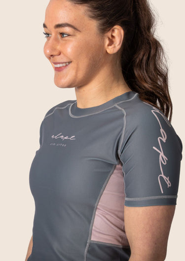 Women’s ash‑rose technical BJJ rashguard; muted pink on grey colour with underarm mesh ventilation.