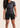 Women’s mid‑length compression shorts in black; high‑waisted design; moisture‑wicking fabric.