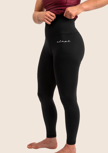Women’s high‑waisted BJJ training leggings in black with minimalist design; squat‑proof four‑way stretch.