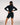 A woman wearing a black long-sleeve rashguard and matching black compression shorts, shown from the back against a plain light gray studio background.