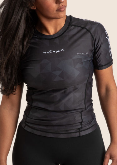 Women’s prism BJJ rashguard in black with subtle geometric pattern; short sleeves. Unique womens fit.