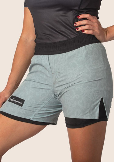 Unisex dual‑layer combination shorts with sage green paisley pattern; built‑in Lycra liner; secure fit.