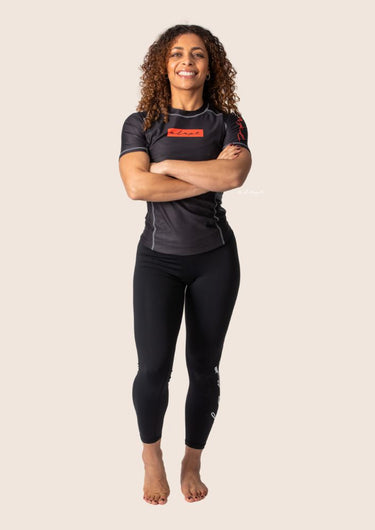 Women’s technical BJJ rashguard in black and red, featuring four‑way stretch and mesh ventilation.