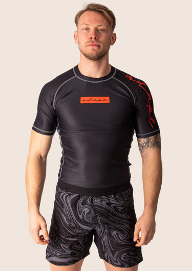 Men’s technical BJJ rashguard in black and red, featuring four‑way stretch and mesh ventilation.