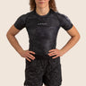 Unisex Jiu-Jitsu dual‑layer combination shorts with black paisley pattern; built‑in compression liner; adjustable fit. Womens Prism BJJ rashguard in black Jacquard Lycra with geometric prism pattern, short sleeves, compression fit. 