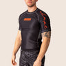Men’s technical BJJ rashguard in black and red, featuring four‑way stretch and mesh ventilation.