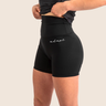 Women’s mid‑length compression shorts in black; high‑waisted design; moisture‑wicking fabric.