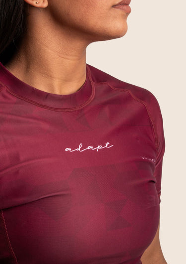 Women’s prism BJJ rashguard in maroon with geometric prism design; short sleeves.