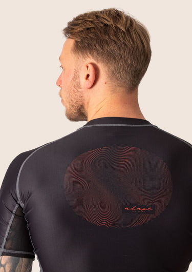 Men’s technical BJJ rashguard in black and red, featuring four‑way stretch and mesh ventilation.