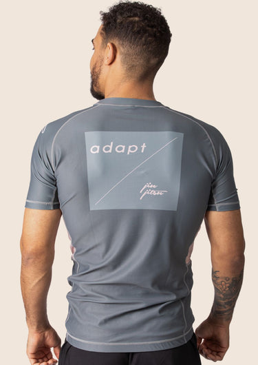 Men’s ash‑rose technical BJJ rashguard with muted pink‑rose hue and performance mesh panels