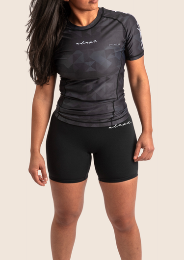 Women’s mid‑length compression shorts in black; high‑waisted design; moisture‑wicking fabric.